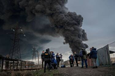 Journalists and residents stand as smoke rises after an attack by Russian army in Odessa, on April 3, 2022. - Air strikes rocked Ukraine's strategic Black Sea port Odessa early Sunday morning, according to an interior ministry official, after Kyiv had warned that Russia was trying to consolidate its troops in the south. (Photo by BULENT KILIC / AFP) (Photo by BULENT KILIC/AFP via Getty Images)