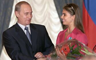 Russian President Vladimir Putin (L) hands flowers to Alina Kabayeva, Russian rhytmic gymnastics star and Olympic prize winner, after awarding her with an Order of Friendship during annual award ceremony in the Kremlin 08 June 2001.   AFP PHOTO     EPA POOL/SERGEI CHIRIKOV        (Photo credit should read SERGEI CHIRIKOV/AFP via Getty Images)