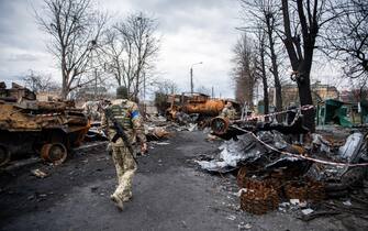 IRPIN, UKRAINE - 2022/04/06: Soldiers walk past destroyed vehicles and Russian tanks in Irpin, a town near Kyiv from which occupying Russian troops recently withdrew following intense fighting with Ukrainian forces. Russia invaded Ukraine on 24 February 2022, triggering the largest military attack in Europe since World War II. (Photo by Laurel Chor/SOPA Images/LightRocket via Getty Images)
