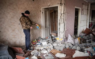 A man dusts off a children's toy inside a relative's apartment that has been heavily damaged due to shelling in Borodyanka, a town outside Kyiv that was recently liberated from Russian occupation.