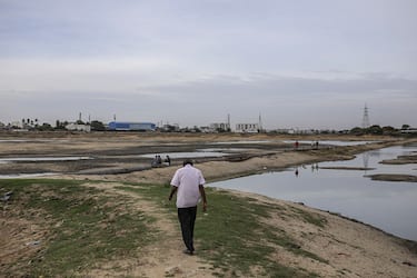 A man walks across the bottom of the dried-out Porur Lake in Chennai, India, on Friday, July 5, 2019. Failed rains last year and delays in this years annual monsoon have left nearly half of India facing drought-like conditions, according to the South Asia Drought Monitor. Photographer: Dhiraj Singh/Bloomberg via Getty Images