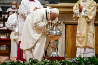 Pope Francis blows inside an amphora containing holy oil during a Chrism Mass inside St. Peter's Basilica, at the Vatican, 14 April 2022. During the Mass the Pontiff blesses a token amount of oil that will be used to administer the sacraments for the year.  ANSA / FABIO FRUSTACI