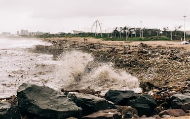 Water from the Indian ocean batters the Blue Lagoon beach as weather patterns worsen following heavy rains earlier in the week in Durban, on April 16, 2022. - Police, army and volunteer rescuers on Friday widened the search for dozens still missing five days after the deadliest storm to strike South Africa's coastal city of Durban in living memory as the death toll rose to 398.. The "unprecedented" floods left a trail of destruction. (Photo by RAJESH JANTILAL / AFP) (Photo by RAJESH JANTILAL/AFP via Getty Images)