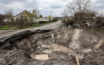 A crater and a destroyed home are pictured in the village of Yatskivka, eastern Ukraine on April 16, 2022. - Russia's military focus now seems to be on seizing the eastern Donbas region, where Russian-backed separatists control the Donetsk and Lugansk areas. Lugansk governor Serhiy Gaidai called on April 16, 2022, for civilians to leave the area while they still can. (Photo by RONALDO SCHEMIDT / AFP) (Photo by RONALDO SCHEMIDT/AFP via Getty Images)