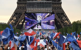 Supporters react after the victory of French President and La Republique en Marche (LREM) party candidate for re-election Emmanuel Macron in France's presidential election, at the Champ de Mars, in Paris, on April 24, 2022. (Photo by bERTRAND GUAY / AFP) (Photo by BERTRAND GUAY/AFP via Getty Images)