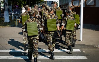 201508231 Moldova, Transnistria, Pridnestrovian Moldavian Republic (PMR) Tiraspol. Soldiers cross the street with communication material on their backs.  They exercise for the official 25th anniversary of their unrecognized country, on September 2.