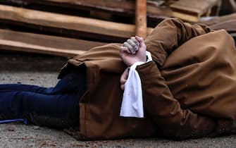 EDITORS NOTE: Graphic content / The body of a man, with his wrists tied behind his back, lies on a street in Bucha, just northwest of the capital Kyiv on April 2, 2022. - The bodies of at least 20 men in civilian clothes were found lying in a single street on April 2, 2022, after Ukrainian forces retook the town of Bucha near Kyiv from Russian troops, AFP journalists said. Russian forces withdrew from several towns near Kyiv in recent days after Moscow's bid to encircle the capital failed, with Ukraine declaring that Bucha had been "liberated". (Photo by RONALDO SCHEMIDT / AFP) (Photo by RONALDO SCHEMIDT/AFP via Getty Images)