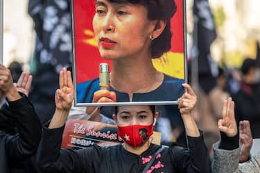 TOPSHOT - A pro-democracy activist holds an image of Myanmar's ousted civilian leader Aung San Suu Kyi as they take part in the "Show Respect for Human Rights in Asia Peace March in Tokyo on December 11, 2021. (Photo by Philip FONG / AFP) (Photo by PHILIP FONG/AFP via Getty Images)
