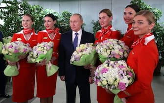epa09803745 Russian President Vladimir Putin (R) poses for pictures with women flight crew of Russian airlines during his visit to the aviation training center of PJSC Aeroflot on the eve of International Women's Day Moscow, Russia, 05 March 2022. The European Union imposed a ban on flights of Russian aircraft over its entire territory. As a mirror measure, Russia officially banned the use of its airspace by airlines from 36 countries. Russian troops entered Ukraine on 24 February prompting the country's president to declare martial law and triggering a series of severe economic sanctions imposed by Western countries on Russia.  EPA/MIKHAEL KLIMENTYEV/SPUTNIK/KREMLIN POOL / POOL