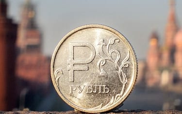 A Russian ruble coin is pictured in front of the Kremlin in central Moscow, on April 28, 2022. - A Russian official said Thursday that the ruble will soon be introduced in areas of Ukraine under Moscow's control, despite Russia earlier insisting it was not seeking to occupy captured territory. A civilian and military administrator of the Russian-controlled region of Kherson in southern Ukraine said Moscow would introduce its currency in the region within the coming days. (Photo by Alexander NEMENOV / AFP) (Photo by ALEXANDER NEMENOV/AFP via Getty Images)