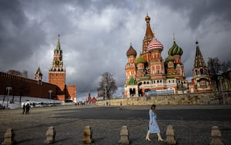 A woman walks outside the Kremlin, Red Square and St. Basil's Cathedral in central Moscow on February 22, 2022. - Russian President Vladimir Putin said on February 22 that he does not plan to restore Russia's empire, a day after he ordered Russian troops to be sent to eastern Ukraine and questioned Ukraine's sovereignty. (Photo by Dimitar DILKOFF / AFP) (Photo by DIMITAR DILKOFF/AFP via Getty Images)