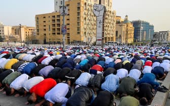 epa09921920 People kneel as they participate in the Eid al-Fitr prayers outside Al-Amin Mosque in downtown Beirut, Lebanon, 02 May 2022. Muslims around the world celebrate Eid al-Fitr, the three days festival marking the end of Ramadan.  Eid al-Fitr is one of the two major holidays in the Islamic calendar.  EPA / WAEL HAMZEH