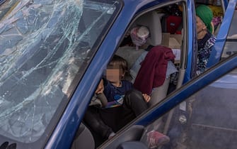 epa09923265 A boy plays in a car with a broken front window after arriving from Mariupol at the evacuation point in Zaporizhzhia, Ukraine, 02 May 2022. On 02 May, thousands of people who were still in Mariupol and other areas in South Ukraine occupied by the Russian army, waited to be evacuated to Ukraine's controlled area by buses and their own cars.  EPA/ROMAN PILIPEY