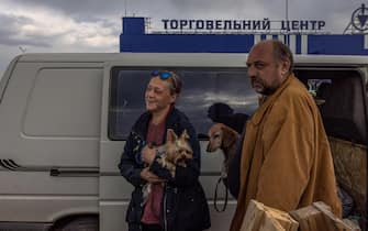 epa09923185 A woman and man stand with dogs after arriving from Mariupol to the evacuation point in Zaporizhzhia, Ukraine, 02 May 2022. On 02 May, thousands of people who were still in Mariupol and other areas in South Ukraine occupied by the Russian army, waited to be evacuated to Ukraine's controlled area by buses and their own cars.  EPA / ROMAN PILIPEY