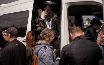 ZAPORIZHZHIA, UKRAINE - MAY 02: People disembark a van to be registered by police after arriving at an evacuation point for people fleeing Mariupol, Melitopol and the surrounding towns under Russian control on May 02, 2022 in Zaporizhzhia, Ukraine. Dozens of refugees were expected to arrive here from Mariupol, including the Azovstal steel facility, following extensive negotiations between representatives of Ukraine, Russia, the United Nations and the International Committee of the Red Cross.  (Photo by Chris McGrath / Getty Images)
