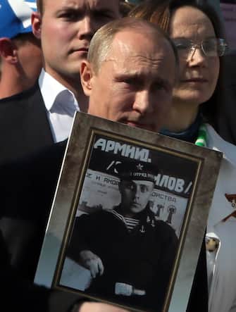 Russian President Vladimir Putin holds a portrait of his father as he takes part in the Immortal Regiment march during the Victory Day celebrations in Moscow.  Moscow, RUSSIA - 09/05/2015 / GREENFIELD_131401 / Credit: GREENFIELD / SIPA / 1505101326
