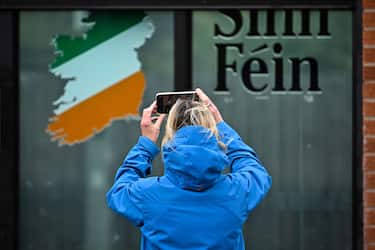 BELFAST, NORTHERN IRELAND - MAY 04: A member of the public takes a picture of the Sinn Fein office on Falls Road ahead of voters going to the polls on Thursday on May 4, 2022 in Belfast,Northern Ireland. Northern Ireland goes to the polls tomorrow to vote for assembly members in what could be a historic change for the country's politics. For the first time in Northern Ireland's 100-year existence, Unionists could see nationalist party Sinn FÃ©in could becoming the largest party. (Photo by Jeff J Mitchell/Getty Images)