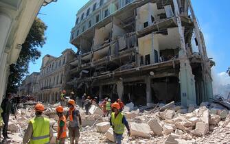 epa09930581 Emergency teams work on the search and rescue of victims and debris removal after an explosion at Hotel Saratoga, in Havana, Cuba, 06 May 2022. Cuban authorities indicated that the preliminary number of victims after the explosion registered this 06 May at the Saratoga hotel in Havana is at least eight dead, 13 people missing and 30 hospitalized.  EPA/Ernesto Mastrascusa