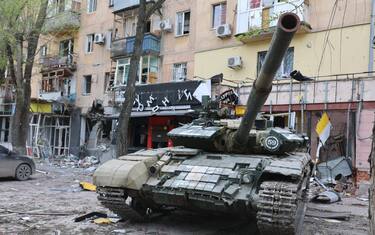 MARIUPOL, UKRAINE - MAY 04: A tank is seen in front of the damaged building as Russian attacks continue in Mariupol, Ukraine on May 04, 2022. Residents of Mariupol at this time are trying to survive on their own and in evacuation camps. (Photo by Leon Klein/Anadolu Agency via Getty Images)