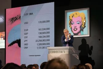 epa09936994 Christie's auctioneer claps after ending the auction of 'Shot Sage Blue Marilyn' by Andy Warhol which sold for $170 million dollars during an Evening Sale of works from The Collection of Thomas and Doris Amman at Christie's Auction House in New York, New York, USA, 09 May 2022.  EPA/SARAH YENESEL