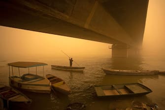 TOPSHOT - A fisherman paddles his boat during a sandstorm in Iraq's southern city of Basra on May 16, 2022. - Another sandstorm that descended on climate-stressed Iraq sent at least 4,000 people to hospital with breathing problems and led to the closure of airports, schools and public offices across the country. (Photo by Hussein FALEH / AFP) (Photo by HUSSEIN FALEH/AFP via Getty Images)