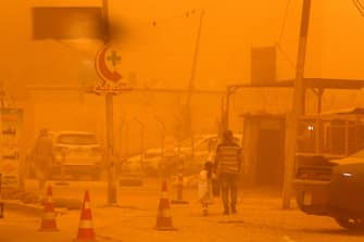 A thick cloud of dust engulfs the Kahramana square in the Karrada negihbourhood of Iraq's capital Baghdad, on May 16, 2022. (Photo by Sabah ARAR / AFP) (Photo by SABAH ARAR/AFP via Getty Images)