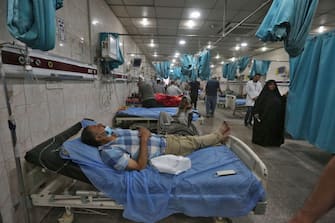 Patients suffering from breathing problems exacerbated by a heavy dust storm receive care at Sheikh Zayed Hospital in Iraq's capital Baghdad on May 16, 2022. (Photo by Sabah ARAR / AFP) (Photo by SABAH ARAR/AFP via Getty Images)