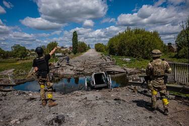 TOPSHOT - Soldiers of the Kraken Ukrainian special forces unit talk to a man at a destroyed bridge on the road near the village of Rus'ka Lozova, north of Kharkiv, on May 16, 2022. - Ukraine has said its troops have regained control of territory on the Russian border near the country's second-largest city of Kharkiv, which has been under constant fire since Moscow's invasion began. (Photo by Dimitar DILKOFF / AFP) (Photo by DIMITAR DILKOFF/AFP via Getty Images)