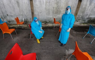 epaselect epa09639820 Health workers take a break from performing COVID-19 swab tests at a makeshift testing facility in Colombo, Sri Lanka, 13 December 2021. The country reported its first case of heavily-mutated coronavirus Omicron variant of concern on 03 December in a Sri Lankan National returning from South Africa.  EPA/CHAMILA KARUNARATHNE