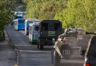 epa09953879 Russian militrary vehicles escort buses carrying Ukrainian servicemen that are being evacuated from the besieged Azovstal steel plant in Mariupol, Ukraine, 17 May 2022. A total of 265 Ukrainian militants, including 51 seriously wounded, have laid down arms and surrendered to Russian forces, the Russian Ministry of Defence said on 17 May 2022. Those in need of medical assistance were sent for treatment to a hospital in Novoazovsk, the ministry states further. Russian President Putin on 21 April 2022 ordered his Defence Minister to not storm but to blockade the plant where a number of Ukrainian fighters were holding out. On 24 February, Russian troops invaded Ukrainian territory starting a conflict that has provoked destruction and a humanitarian crisis. According to the UNHCR, more than six million refugees have fled Ukraine, and a further 7.7 million people have been displaced internally within Ukraine since.  EPA/ALESSANDRO GUERRA
