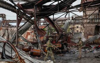 UKRAINE RUSSIA CONFLICT epa09955623 A picture taken during a visit to Mariupol organised by the Russian military shows Russian servicemen check destroyed position of Ukrainian troops on the territory of the Ilyich Iron and Steel Works in Mariupol, Ukraine, 18 May 2022. Ilyich Iron and Steel Works of Mariupol is the largest European producer of cold-rolled and galvanized plates. On 24 February, Russian troops invaded Ukrainian territory starting a conflict that has provoked destruction and a humanitarian crisis. According to the UNHCR, more than 6.3 million refugees have fled Ukraine, and a further 7.7 million people have been displaced internally within Ukraine since. EPA/SERGEI ILNITSKY