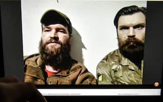 epa09934781 A video of a press conference from the Azovstal steel plant in Mariupol by Azov regiment servicemen Illia Samoilenko (R) and Sviatoslav Palamar (L) is seen on a computer screen in Kyiv, Ukraine, 08 May 2022. On 24 February, Russian troops had entered Ukrainian territory in what the Russian president declared a 'special military operation', resulting in fighting and destruction in the country, a huge flow of refugees, and multiple sanctions against Russia.  EPA/OLEG PETRASYUK