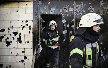 Firefighters extinguish a fire on a house after shelling on the 17th day of the Russian invasion of Ukraine in Kyiv on March 12, 2022. - Russian forces are positioned around Kiev on March 12, 2022 and are "blocking" Mariupol, where thousands of people are suffering a devastating siege, in southern Ukraine, a country that has been bombed for more than two weeks. (Photo by Aris Messinis / AFP) (Photo by ARIS MESSINIS/AFP via Getty Images)