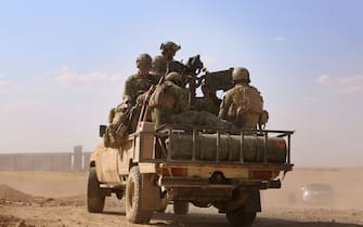 Armed men in uniform identified by Syrian Democratic forces as US special operations forces ride in the back of a pickup truck in the village of Fatisah in the northern Syrian province of Raqa on May 25, 2016. 
US-backed Syrian fighters and Iraqi forces pressed twin assaults against the Islamic State group, in two of the most important ground offensives yet against the jihadists. The Syrian Democratic Forces (SDF), formed in October 2015, announced on May 24 its push for IS territory north of Raqa city, which is around 90 kilometres (55 miles) south of the Syrian-Turkish border and home to an estimated 300,000 people. The SDF is dominated by the Kurdish People's Protection Units (YPG) -- largely considered the most effective independent anti-IS force on the ground in Syria -- but it also includes Arab Muslim and Christian fighters.

 / AFP / DELIL SOULEIMAN        (Photo credit should read DELIL SOULEIMAN/AFP via Getty Images)