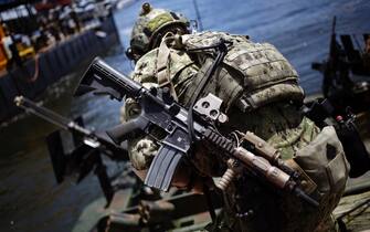 962188338 A U.S. Navy Special Warfare Combatant-Craft Crewman (SWCC) secures a Special Operations Craft Riverine (SOC-R) boat during an International Special Operations Forces capacities exercise outside the Special Operations Forces Industry Conference (SOFIC) in Tampa, Florida, U.S., on Wednesday, May 23, 2018. The conference offers the SOF community a place to interact with industry and to collaborate on the challenges, initiatives and way-ahead in delivering the most cutting-edge capabilities into the hands of SOF operators. Photographer: Luke Sharrett/Bloomberg