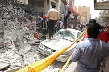 Iranians gather at the site where a ten-storey building collapsed in the southwestern city of Abadan on May 23, 2022. - At least four people died and dozens were trapped under the rubble when an unfinished building collapsed in southwestern Iran, officials said. (Photo by TASNIM NEWS / AFP) (Photo by -/TASNIM NEWS/AFP via Getty Images)