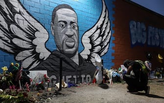 HOUSTON, TEXAS - JUNE 08: Joshua Broussard kneels in front of a memorial and mural that honors George Floyd at the Scott Food Mart corner store in Houston's Third Ward where Mr. Floyd grew up on June 8, 2020 in Houston, Texas. The funeral and burial for George Floyd will be held June 9. Floyd died on May 25th while in Minneapolis police custody, sparking nationwide protests. (Photo by Joe Raedle/Getty Images)