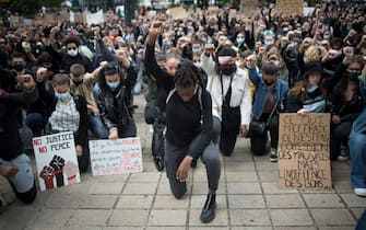 TOPSHOT - People raise their fist and stand on their knees as they demonstrate in Nantes, on June 8, 2020, during a 'Black Lives Matter' worldwide protests against racism and police brutality in the wake of the death of George Floyd, an unarmed black man killed while apprehended by police in Minneapolis. (Photo by Loic VENANCE / AFP) (Photo by LOIC VENANCE/AFP via Getty Images)