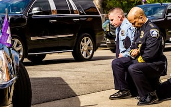 TOPSHOT - Minneapolis Police Chief Medaria Arradondo (R) kneels as the remains of George Floyd are taken to a memorial service in his honor on June 4, 2020, in Minneapolis, Minnesota. - On May 25, 2020, Floyd, a 46-year-old black man suspected of passing a counterfeit $20 bill, died in Minneapolis after Derek Chauvin, a white police officer, pressed his knee to Floyd's neck for almost nine minutes. (Photo by kerem yucel / AFP) (Photo by KEREM YUCEL/AFP via Getty Images)