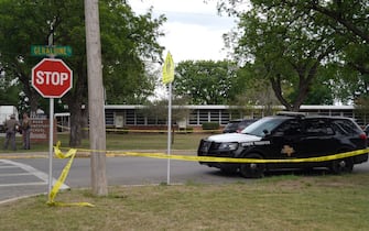 Sheriff crime scene tape is seen outside of Robb Elementary School as State troopers guard the area in Uvalde, Texas, on May 24, 2022. - An 18-year-old gunman killed 14 children and a teacher at an elementary school in Texas on Tuesday, according to the state's governor, in the nation's deadliest school shooting in years. (Photo by allison dinner / AFP) (Photo by ALLISON DINNER/AFP via Getty Images)