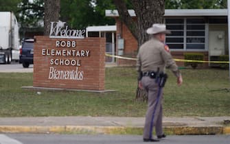 TOPSHOT - An officer walks outside of Robb Elementary School in Uvalde, Texas, on May 24, 2022. - An 18-year-old gunman killed 14 children and a teacher at an elementary school in Texas on Tuesday, according to the state's governor, in the nation's deadliest school shooting in years. (Photo by allison dinner / AFP) (Photo by ALLISON DINNER/AFP via Getty Images)
