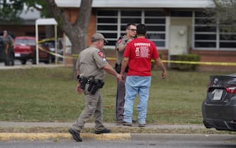 Law enforcement officers speak to a man outside of Robb Elementary School in Uvalde, Texas, on May 24, 2022. - A teenage gunman killed 18 young children in a shooting at an elementary school in Texas on Tuesday, in the deadliest US school shooting in years.
The attack in Uvalde, Texas -- a small community about an hour from the Mexican border -- is the latest in a spree of deadly shootings in America, where horror at the cycle of gun violence has failed to spur action to end it. (Photo by allison dinner / AFP) (Photo by ALLISON DINNER/AFP via Getty Images)