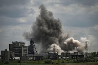 TOPSHOT - Smoke and dirt ascends after a strike at a factory in the city of Soledar at the eastern Ukranian region of Donbas on May 24, 2022, on the 90th day of the Russian invasion of Ukraine. (Photo by ARIS MESSINIS / AFP)