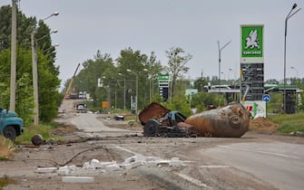 epa09978251 Debris covers a road after new shelling in Kharkiv, Ukraine, 26 May 2022. At least seven people were killed and seventeen injured including a child following new shelling in Kharkiv, as city officials stated. Kharkiv, Ukraine's second-largest city, and surrounding areas had been the target of shelling and airstrikes from Russian forces in the past weeks. Russian troops had entered Ukraine on 24 February causing fighting and destruction and a humanitarian crisis.  EPA/SERGEY KOZLOV