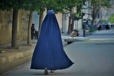 TOPSHOT - A burqa-clad woman walks along a street in Kabul on May 7, 2022. - The Taliban on May 7 imposed some of the harshest restrictions on Afghanistan's women since they seized power, ordering them to cover fully in public, ideally with the traditional burqa. (Photo by Ahmad SAHEL ARMAN / AFP) (Photo by AHMAD SAHEL ARMAN/AFP via Getty Images)