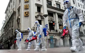 SHANGHAI, CHINA - MAY 28: Sanitation workers wearing personal protective equipment (PPE) spray disinfectant at Nanjing Road Pedestrian Street on May 28, 2022 in Shanghai, China. Shanghai launched a three-phase plan to restore production and life to normal. (Photo by Yang Jianzheng/VCG via Getty Images)