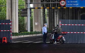 SHANGHAI, CHINA - MAY 29: A police checks the pass of a man on May 29, 2022 in Shanghai, China. (Photo by Hugo Hu/Getty Images)