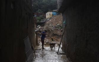 A man removes mud from a damaged house after a landslide in the community Jardim Montes Verdes, Ibura neighbourhood, in Recife, Pernambuco State, Brazil, on May 31, 2022. - The death toll from torrential rains that triggered floods and landslides in northeastern Brazil has risen to 100, officials said Tuesday, as emergency workers searched for more victims. (Photo by SERGIO MARANHAO / AFP) (Photo by SERGIO MARANHAO/AFP via Getty Images)
