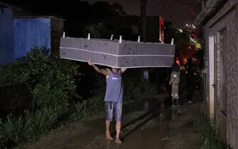 A man carries a mattress after a landslide in the community Vila dos Milagres in Recife, Pernambuco State, Brazil, on May 31, 2022. - Flooding and landslides triggered by torrential rain have now killed at least 106 people in northeastern Brazil, officials said Tuesday as emergency workers continued a desperate search. (Photo by Sergio MARANHAO / AFP) (Photo by SERGIO MARANHAO/AFP via Getty Images)