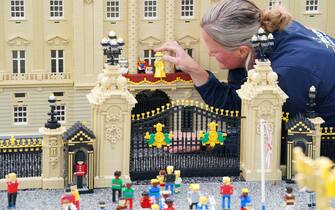 Model Maker Paula Young places a LEGO replica of Queen Elizabeth II, along with other members of the Royal Family, in a display replicating the Royal Balcony scene at Buckingham Palace for the LEGOLAND Resort's Platinum Jubilee Display that was unveiled today. All members of the Royal family took 8 hours to build and are made up of over 200 LEGO Bricks. LEGOLAND Windsor Resort today unveiled its royal-inspired models to celebrate the Queen's Platinum Jubilee. The overall number of bricks used was 18,001 and the models took a total of 281.5 hours to finish. The display also includes includes a street party and picnic scene as well as miniature versions of the royals, the tree of trees and more. Picture date: Tuesday May 31, 2022.